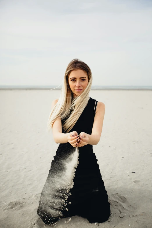 a beautiful woman standing on top of a sandy beach