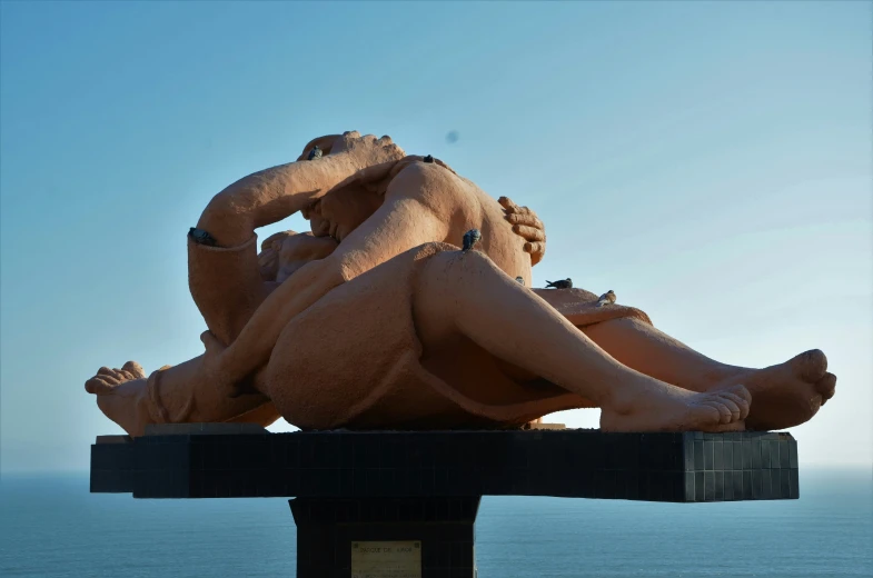 a big statue sitting next to the ocean