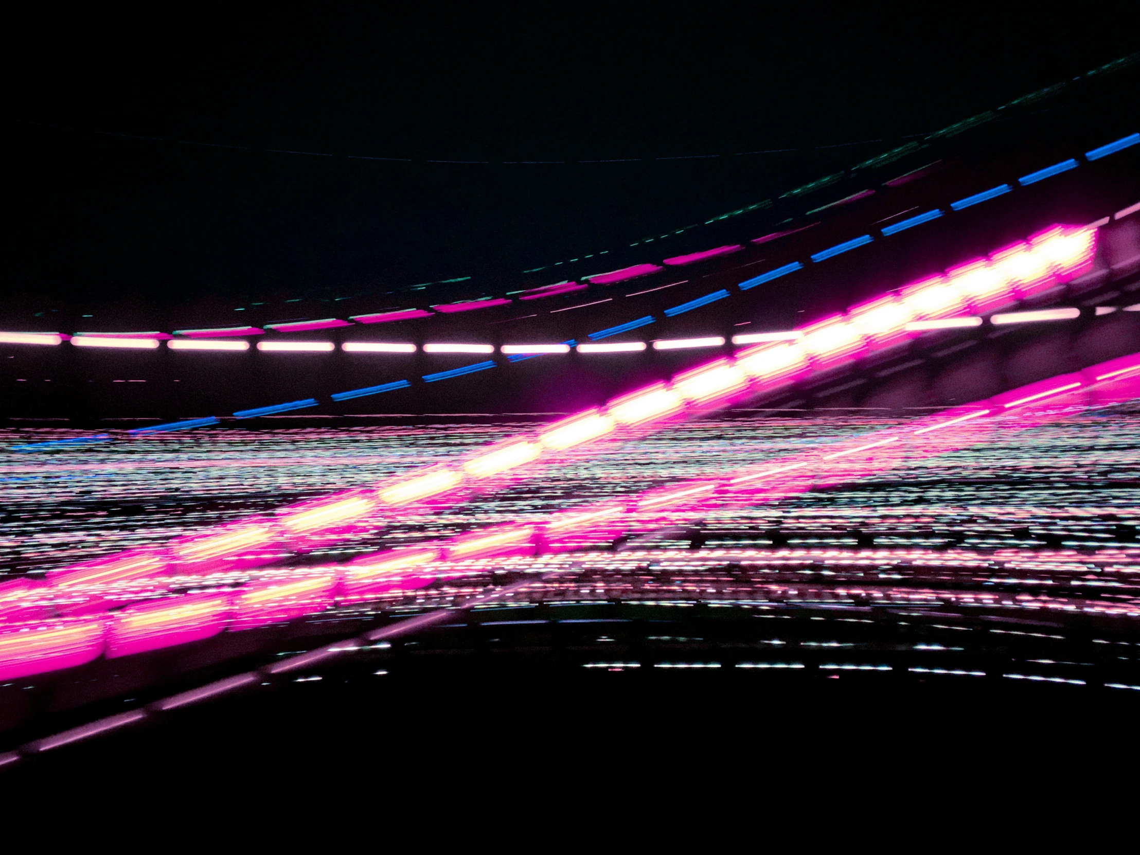 a tunnel in a dimly lit room is lit up with brightly colored light