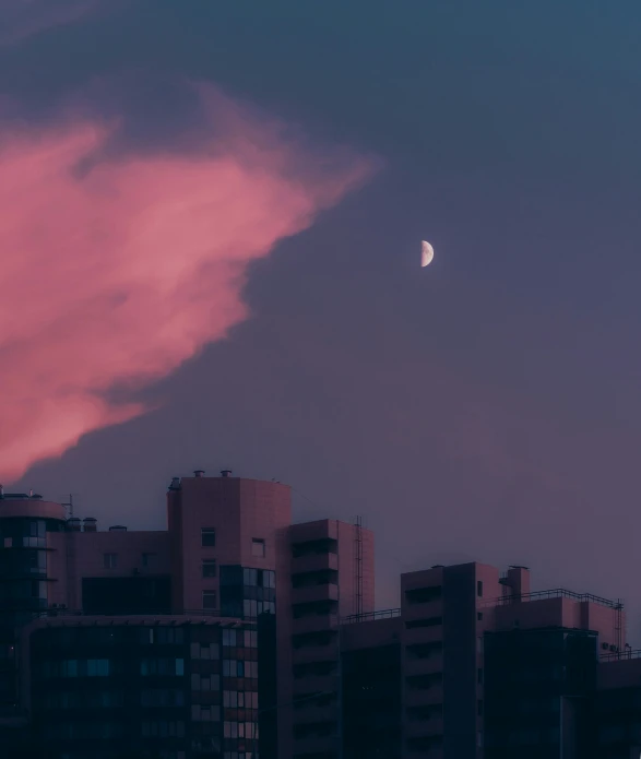 a kite flying through the sky over some tall buildings