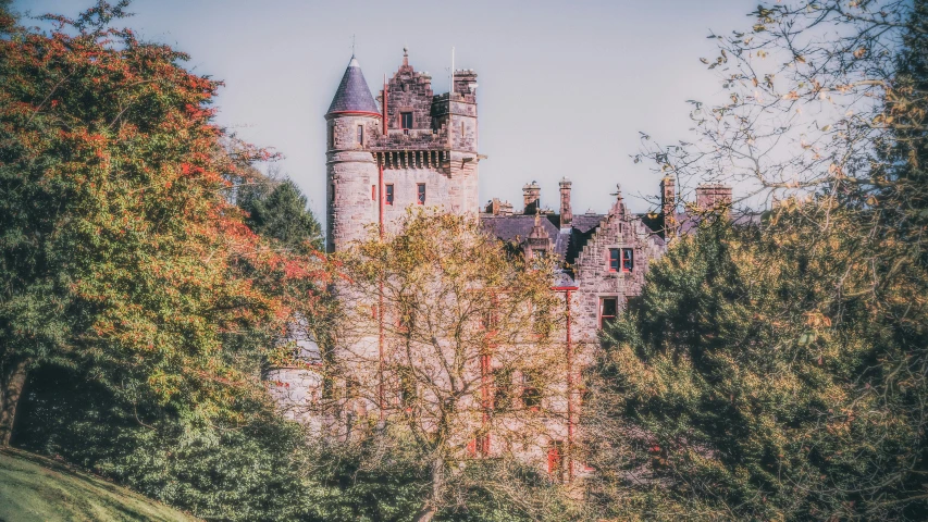 an old castle with red towers in the woods