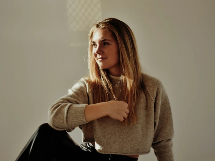 a beautiful woman in a sweater posing for the camera