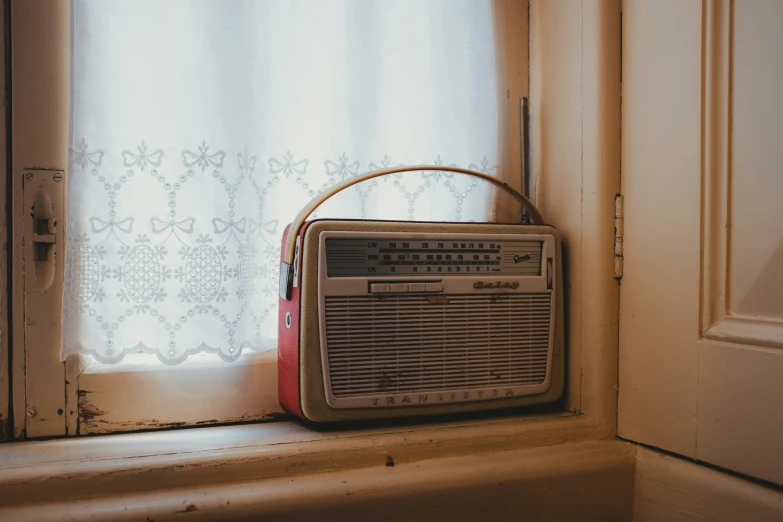 an old radio next to a window sill