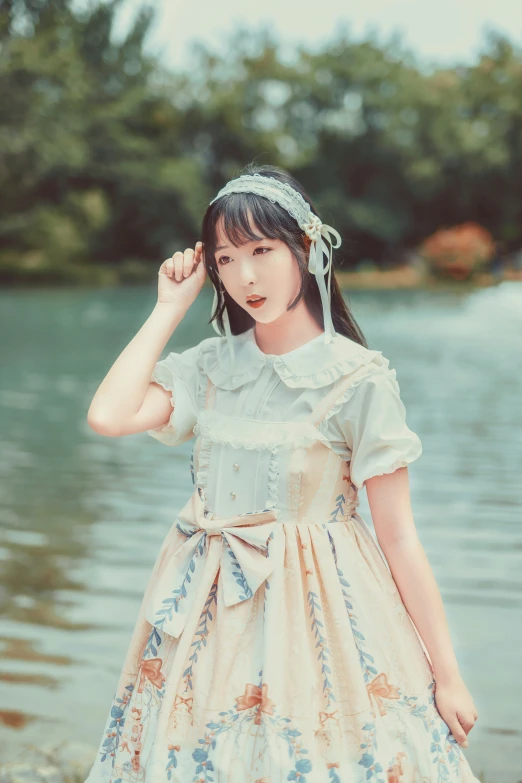 a young asian girl is posing in front of the water