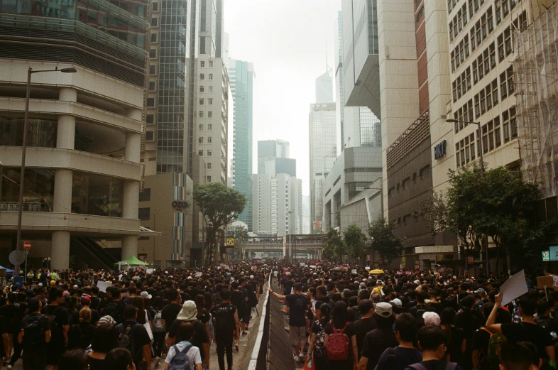 crowd of people walking down street in large city