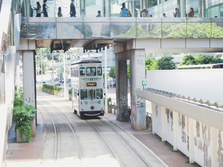 the tram is passing under the glass walkway