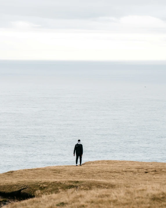 a man is looking out to the ocean from the beach