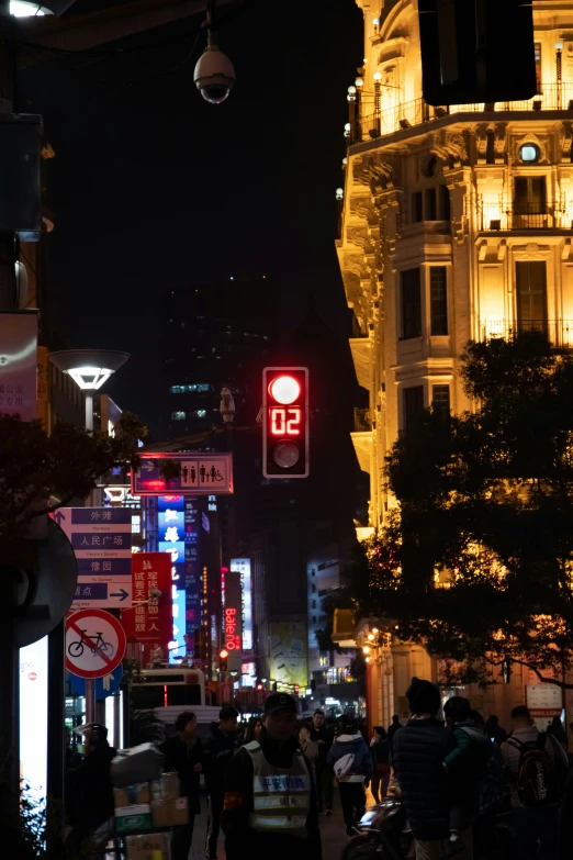 a street scene with people, bicycles and buildings lit up