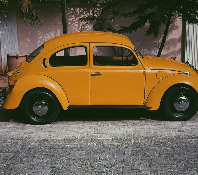 an old vintage beetle is parked in front of a building