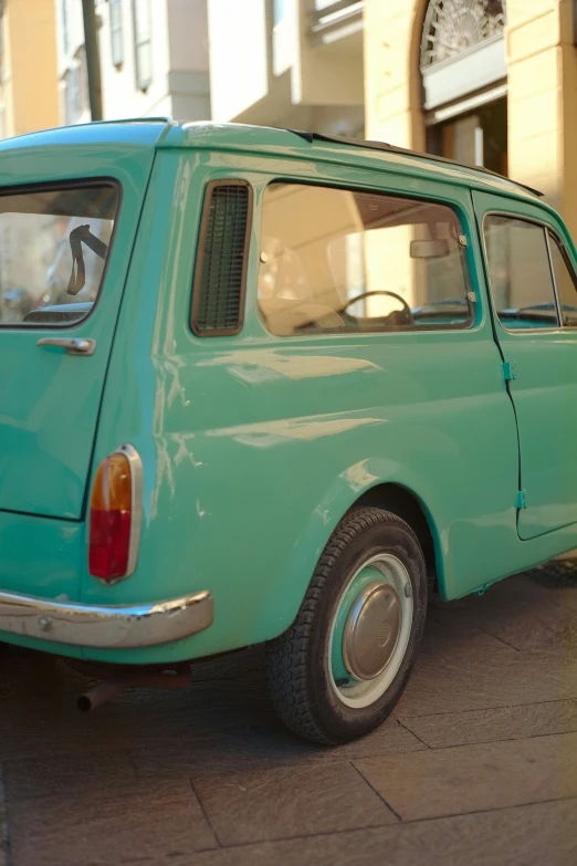 an older model blue and brown car sitting in the street