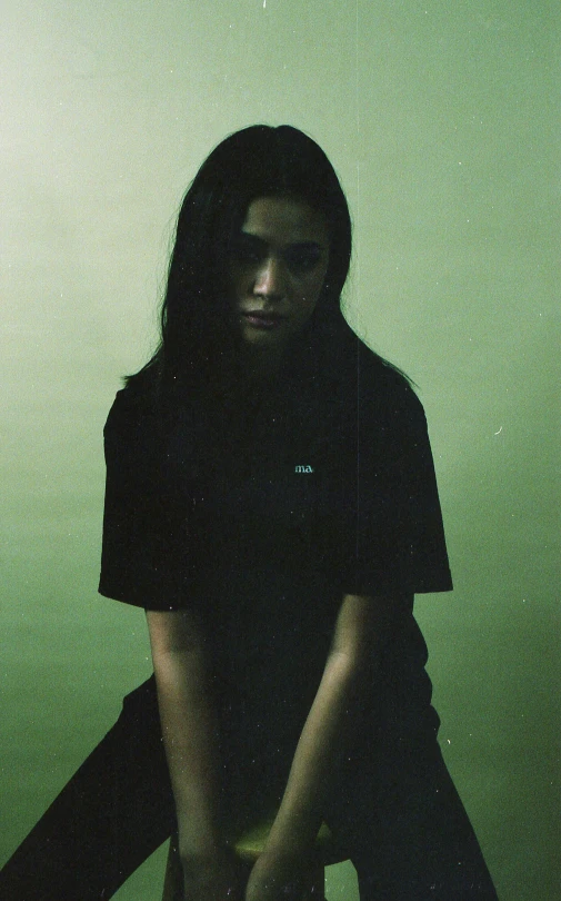 a woman sitting on top of a skateboard in front of a wall