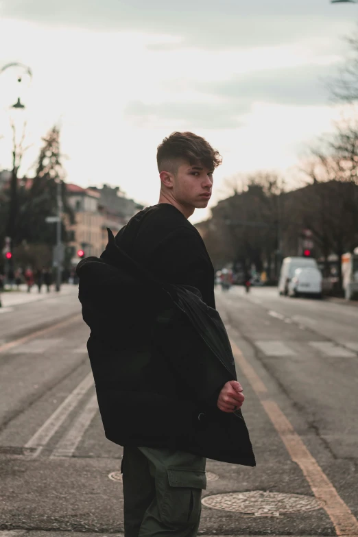 a man standing in the middle of the street with his back to the camera