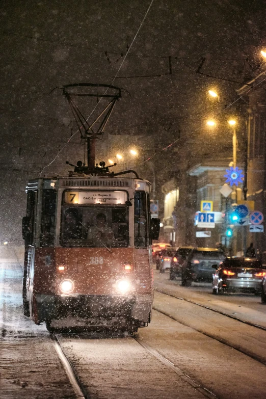 a red trolly with a person on it riding through the snow