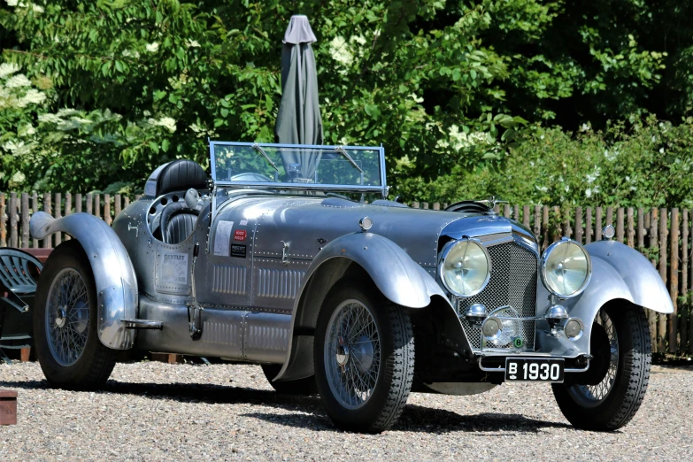 a silver sports car is on display outside