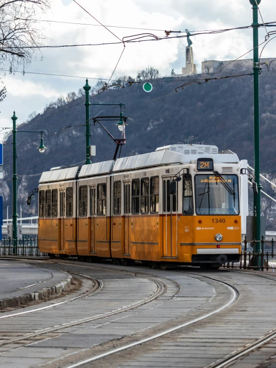 the train is traveling on the tracks on a cloudy day