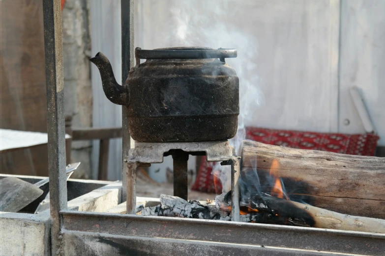 a metal teapot with boiling wood on top