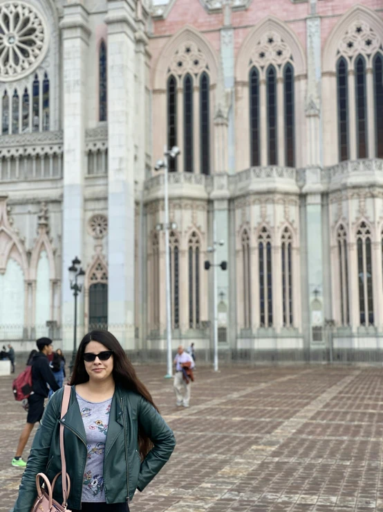 a woman stands by the front entrance to a cathedral