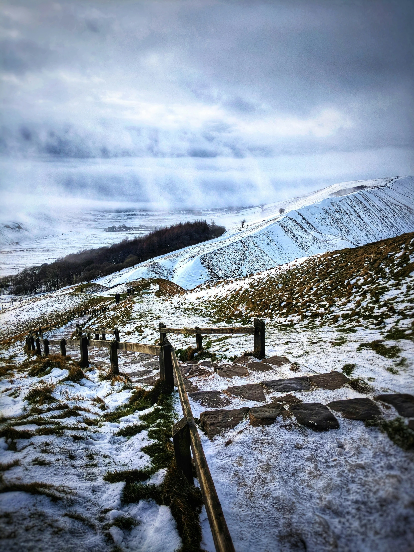 a couple of snow covered hills with trees on them