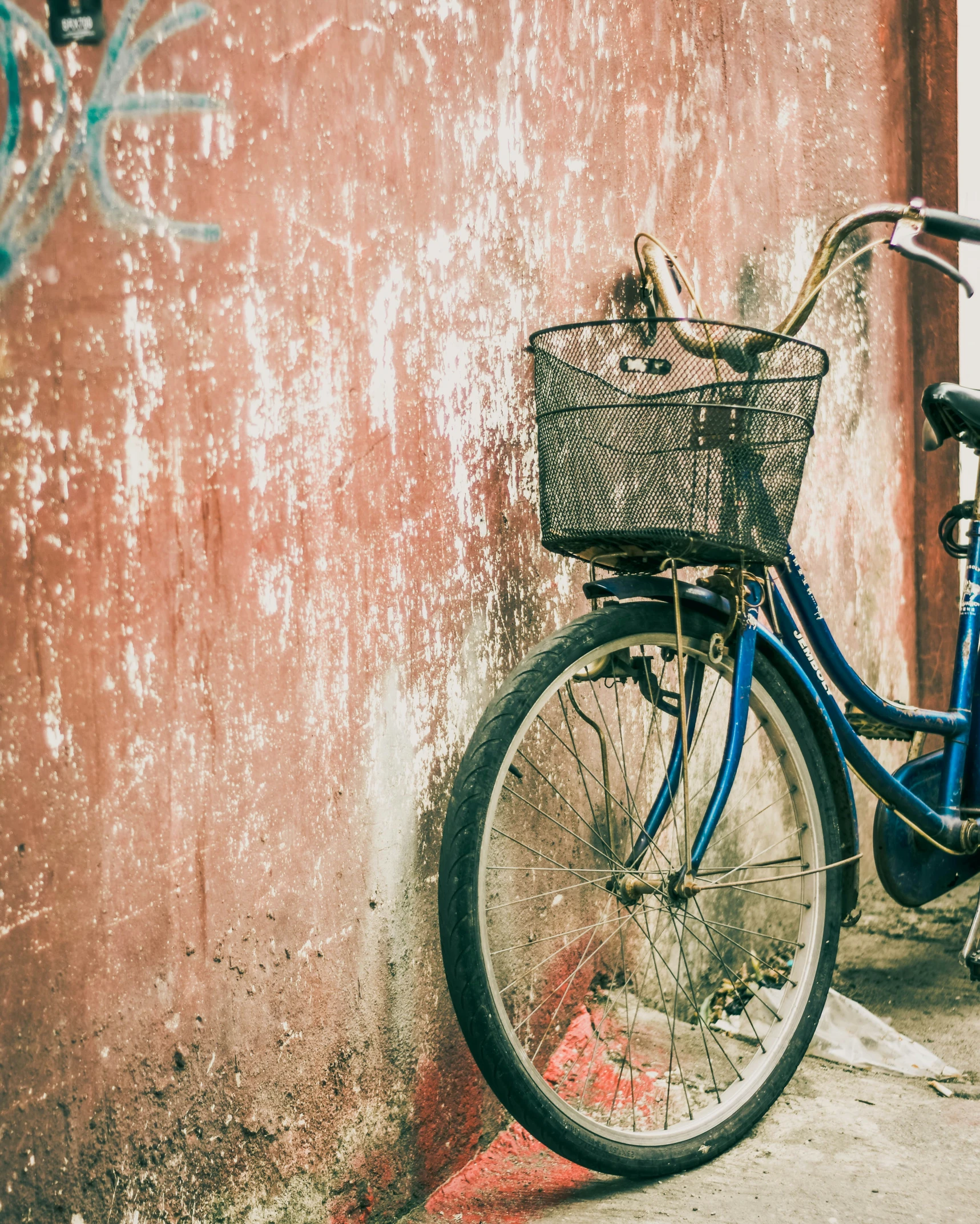 a bicycle is parked on the sidewalk next to a wall