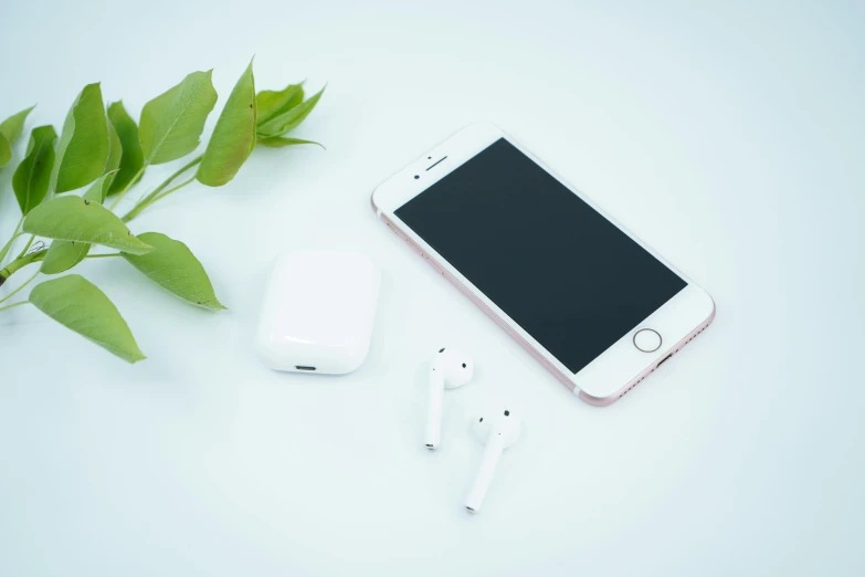 an iphone sitting next to a smart phone and headset