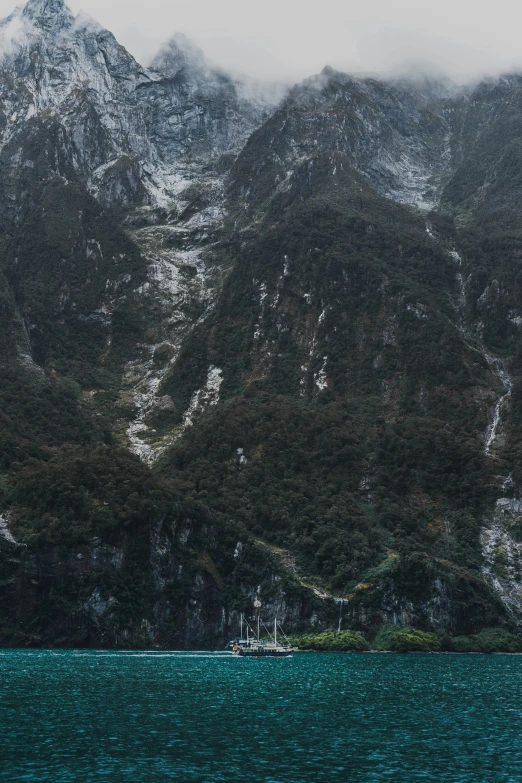 a very large mountain with a boat in the water