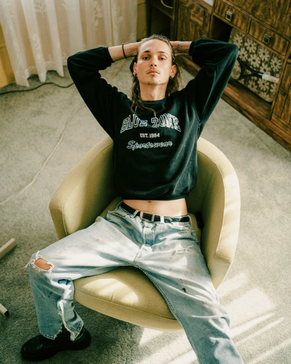 woman sitting on an overstuffed chair and has her hands in her hair