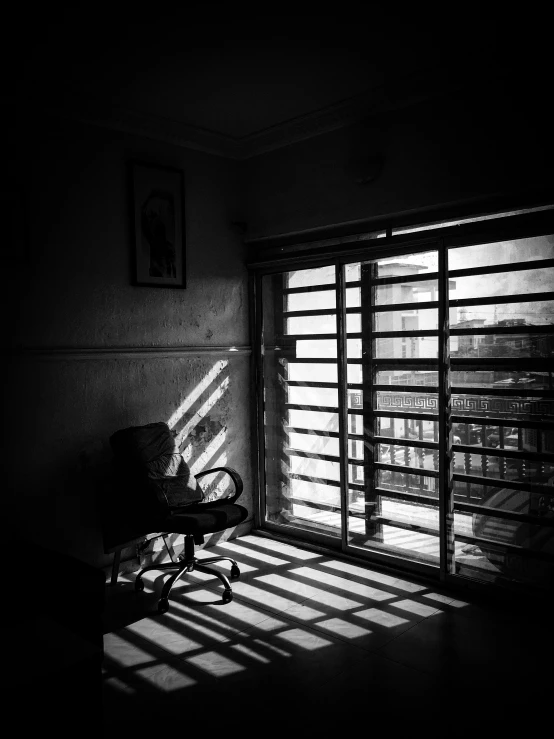 a chair sitting in a room with light coming through the window