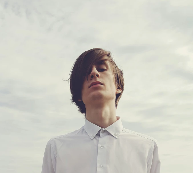 young man looking upward on overcast day