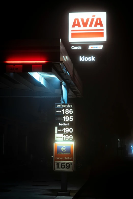 gas station signs lit up in the dark