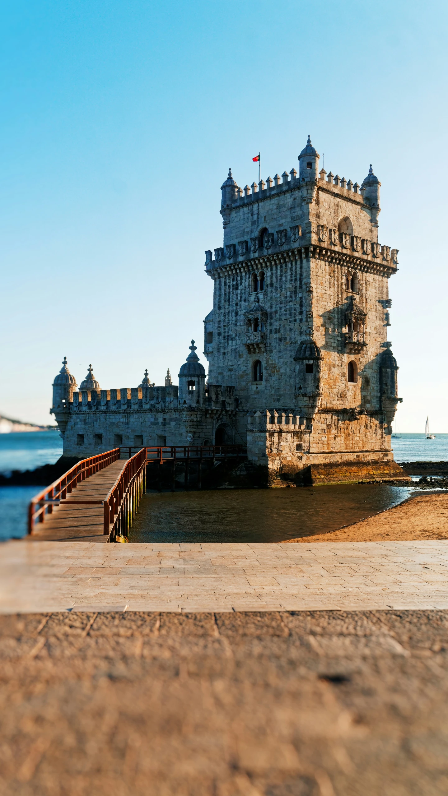 a stone tower with a stairway to it on the beach