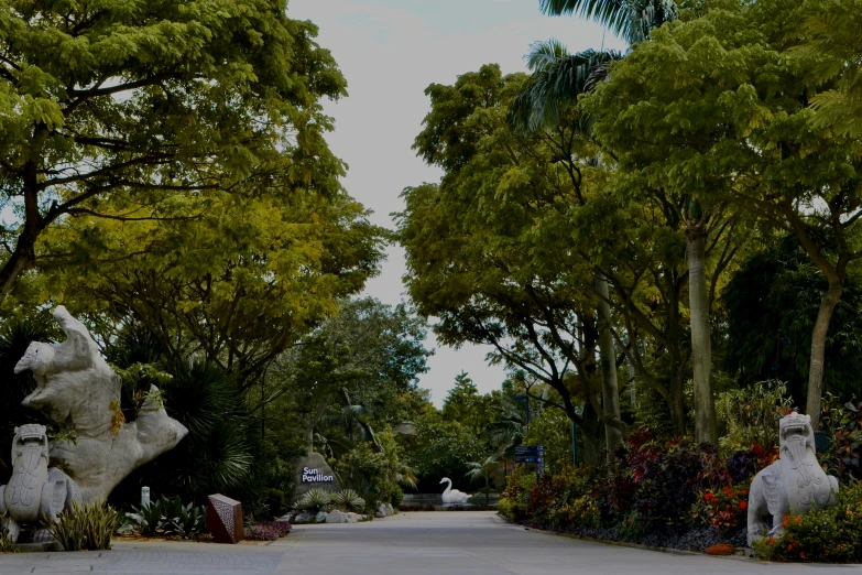 two large white statues sitting on top of a lush green park