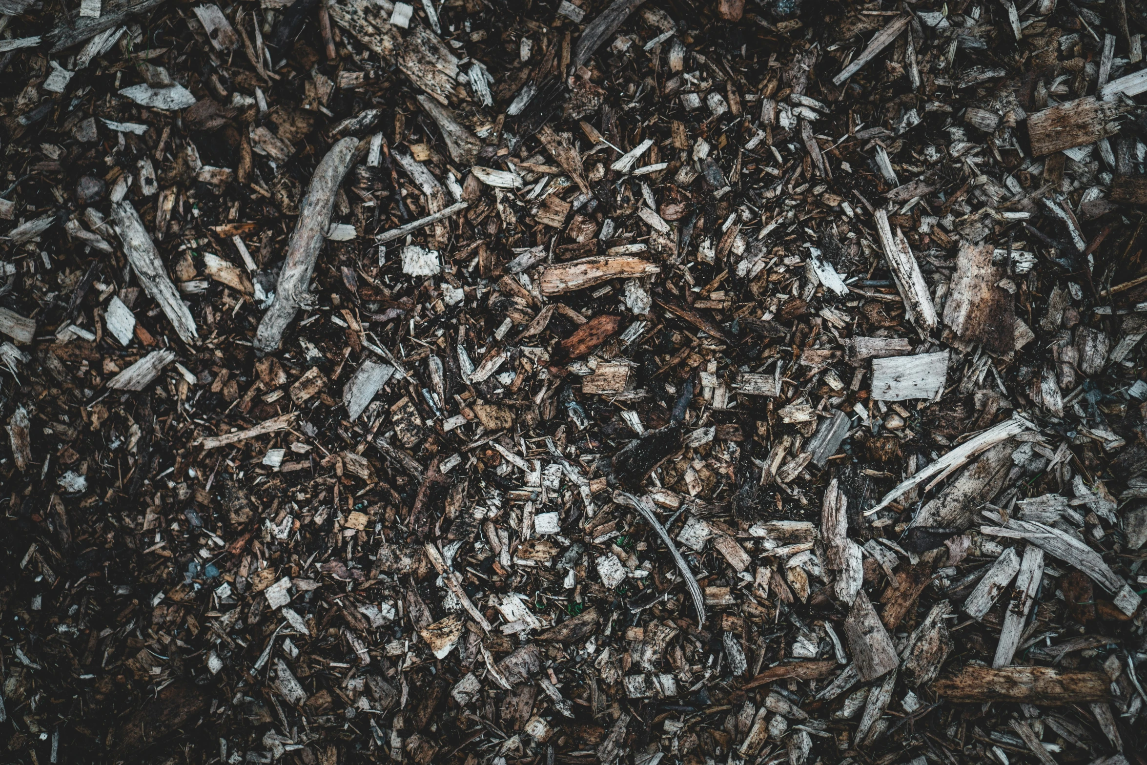 a pile of woodchips with white chippers