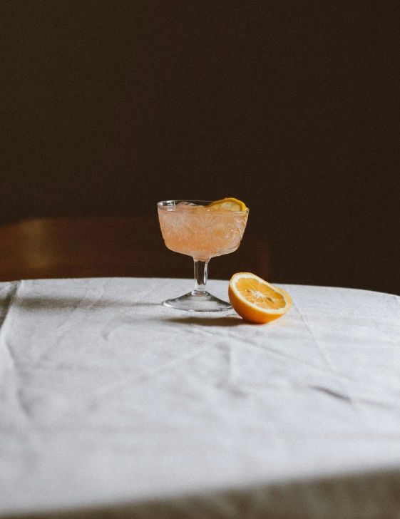 there is a table with a drink and two orange slices on it