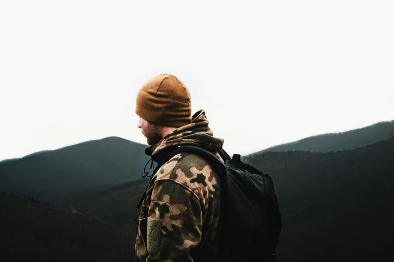 a person with a backpack stands on top of a mountain