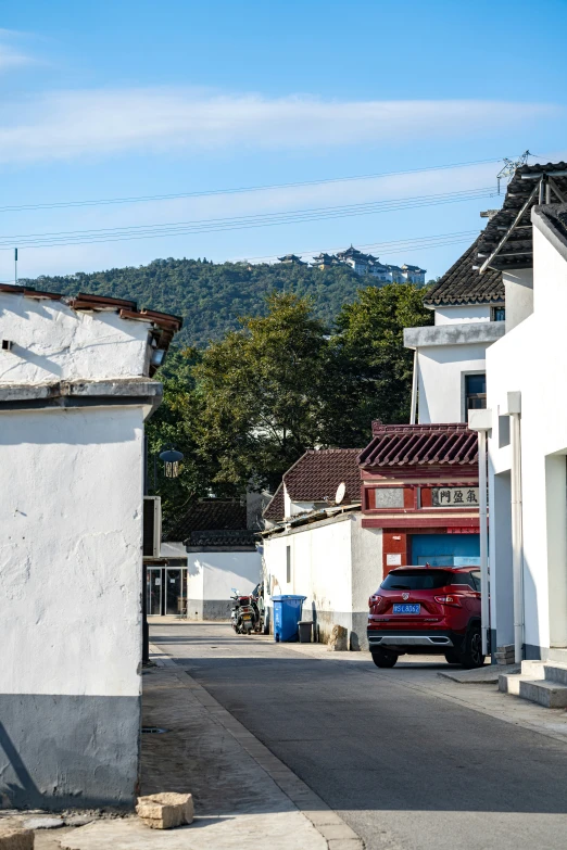 a car that is sitting in the street next to houses