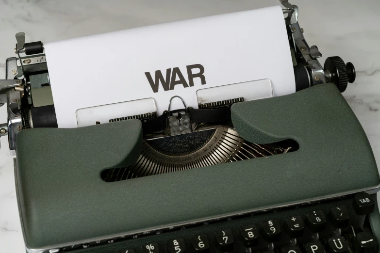 a typewriter with a war note in front of it