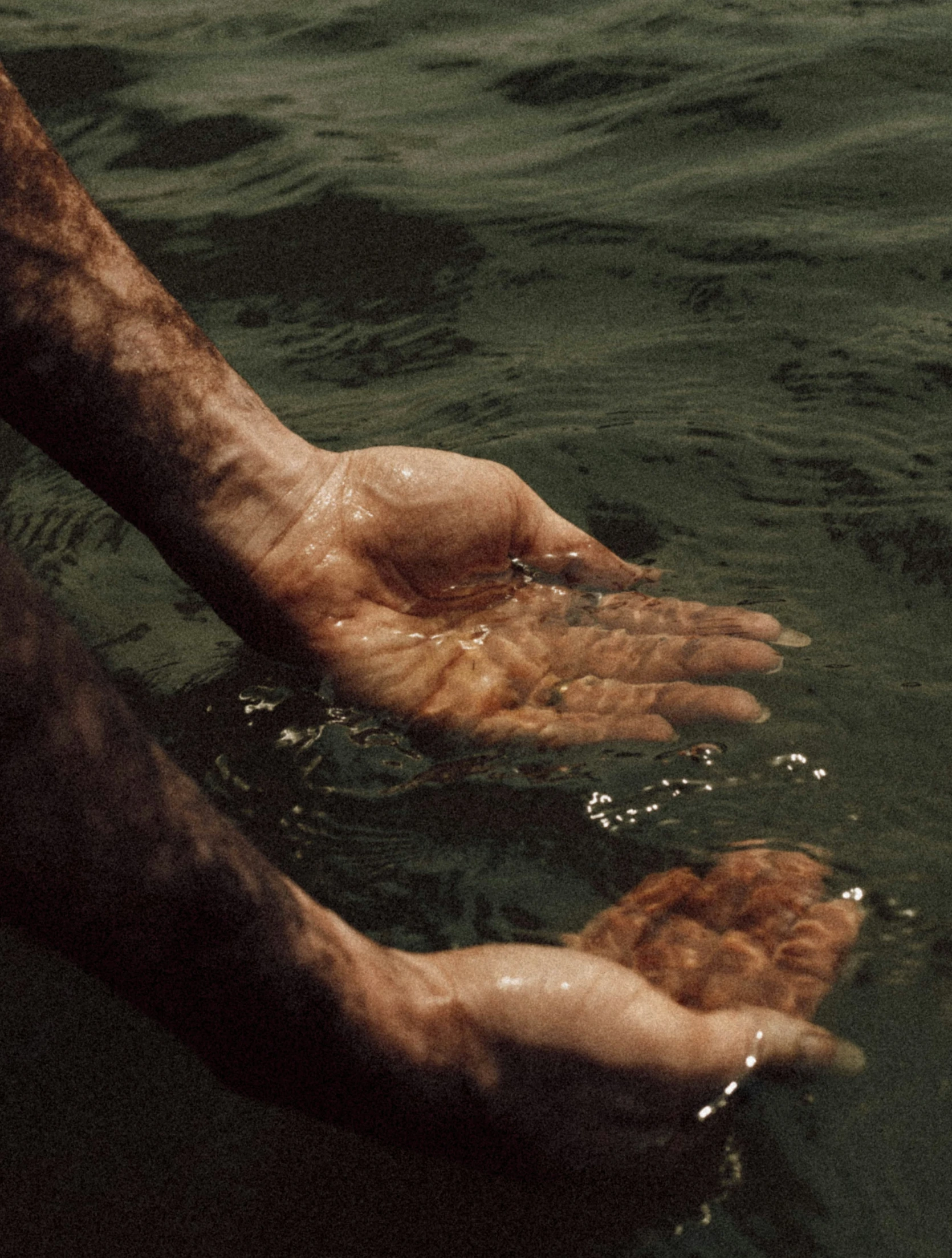 the hands of a man who is standing in water