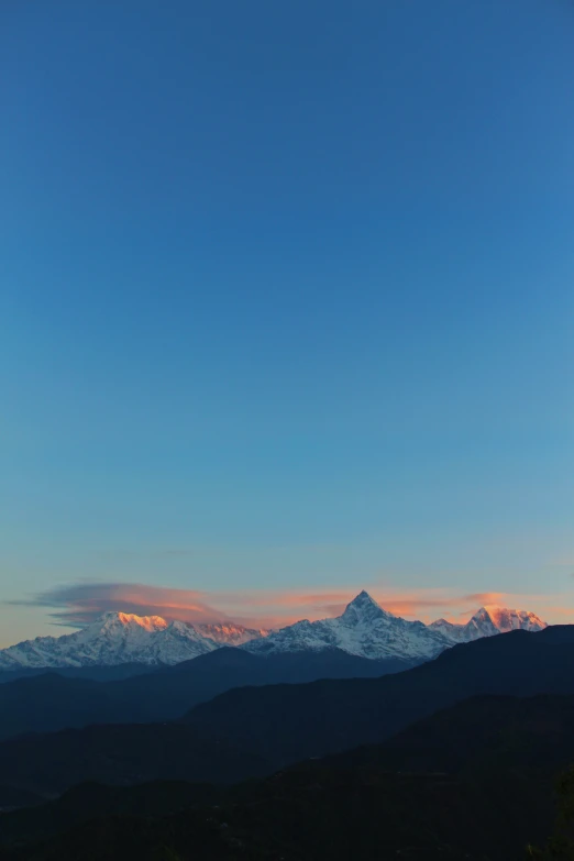 a view of snow covered mountains with sky