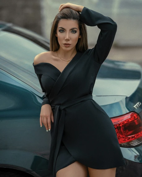 the young model poses in front of her car
