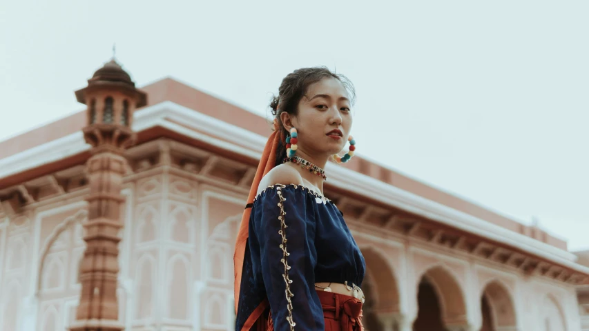 a woman in traditional dress standing in front of a building