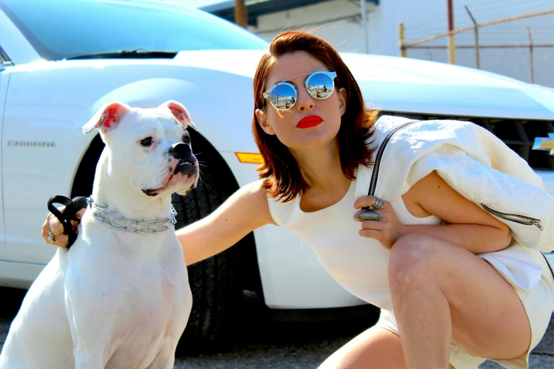 a woman in sunglasses posing with a dog