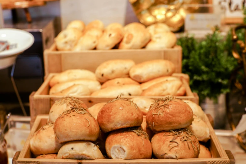 box of rolls and other breads on display in a bakery