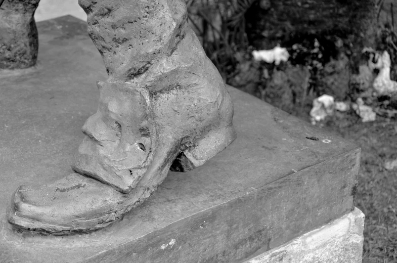 black and white po of stone boot of someone who has fallen over