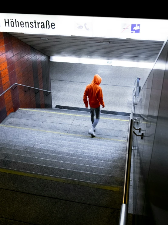 a person in an orange jacket on an escalator