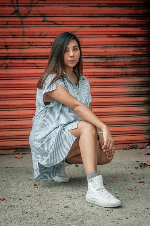 the young woman sits with her legs crossed