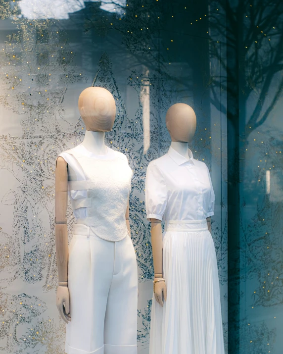 two mannequins dressed in white and standing up