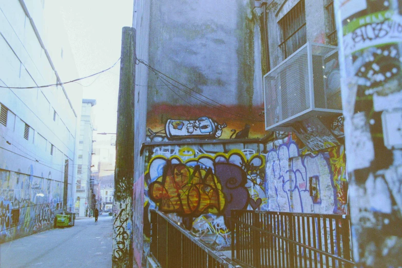 an empty street and some walls with graffiti on them