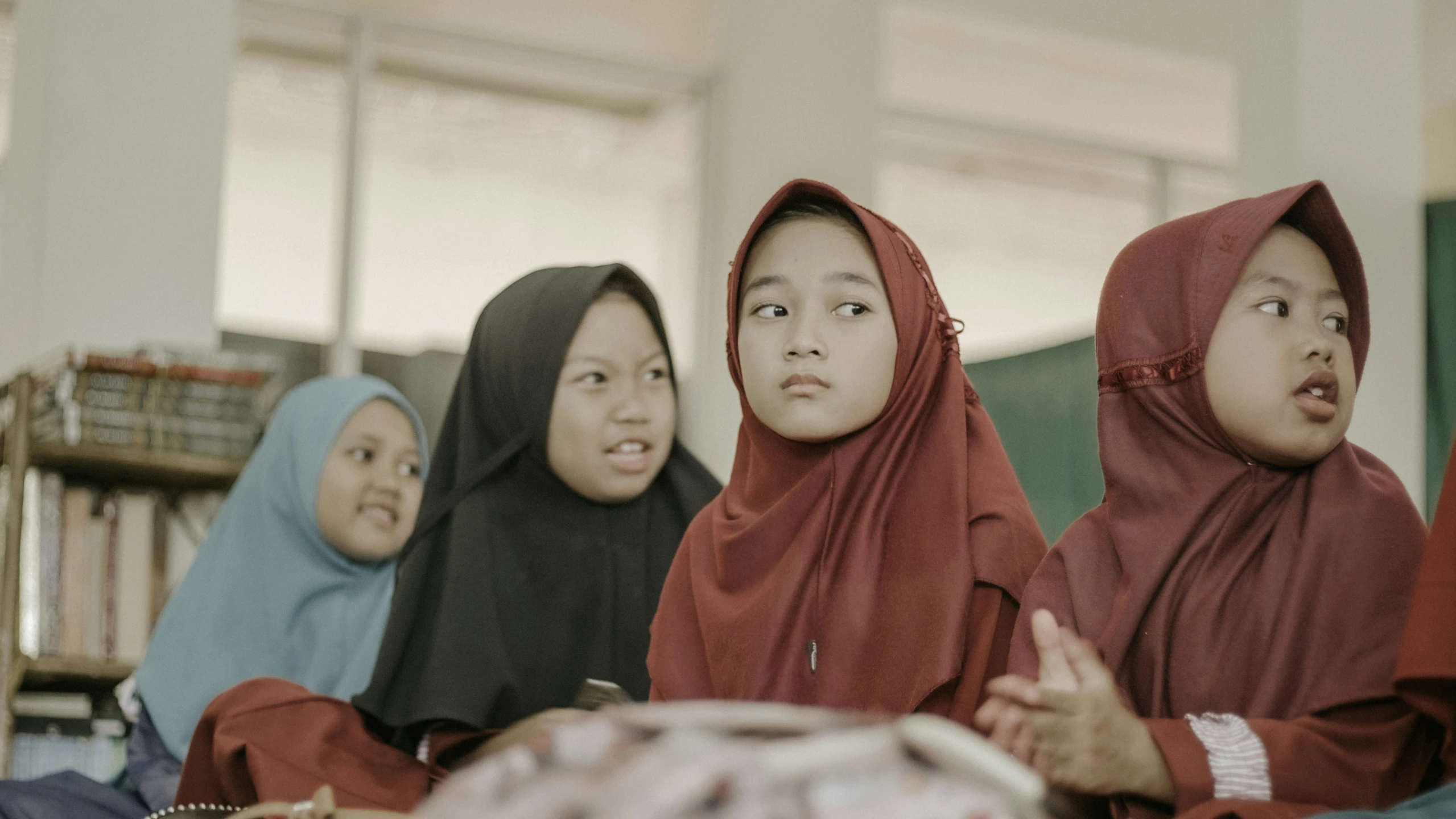 three girls are seated in a group together