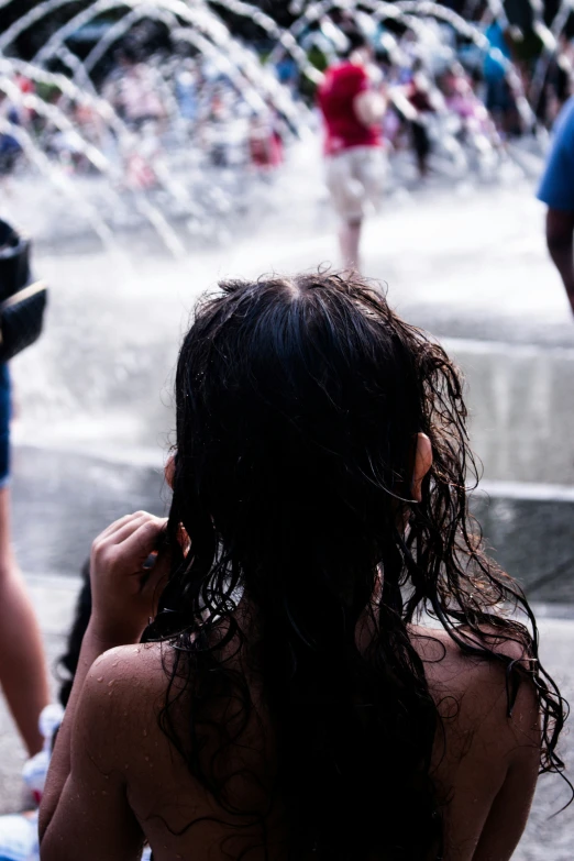 two girls standing next to each other with water spraying out
