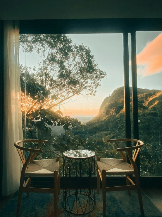 two chairs sitting in front of a window overlooking a mountain view